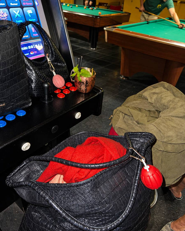 FlamAid Pro roja colgada de una mochila en un bar